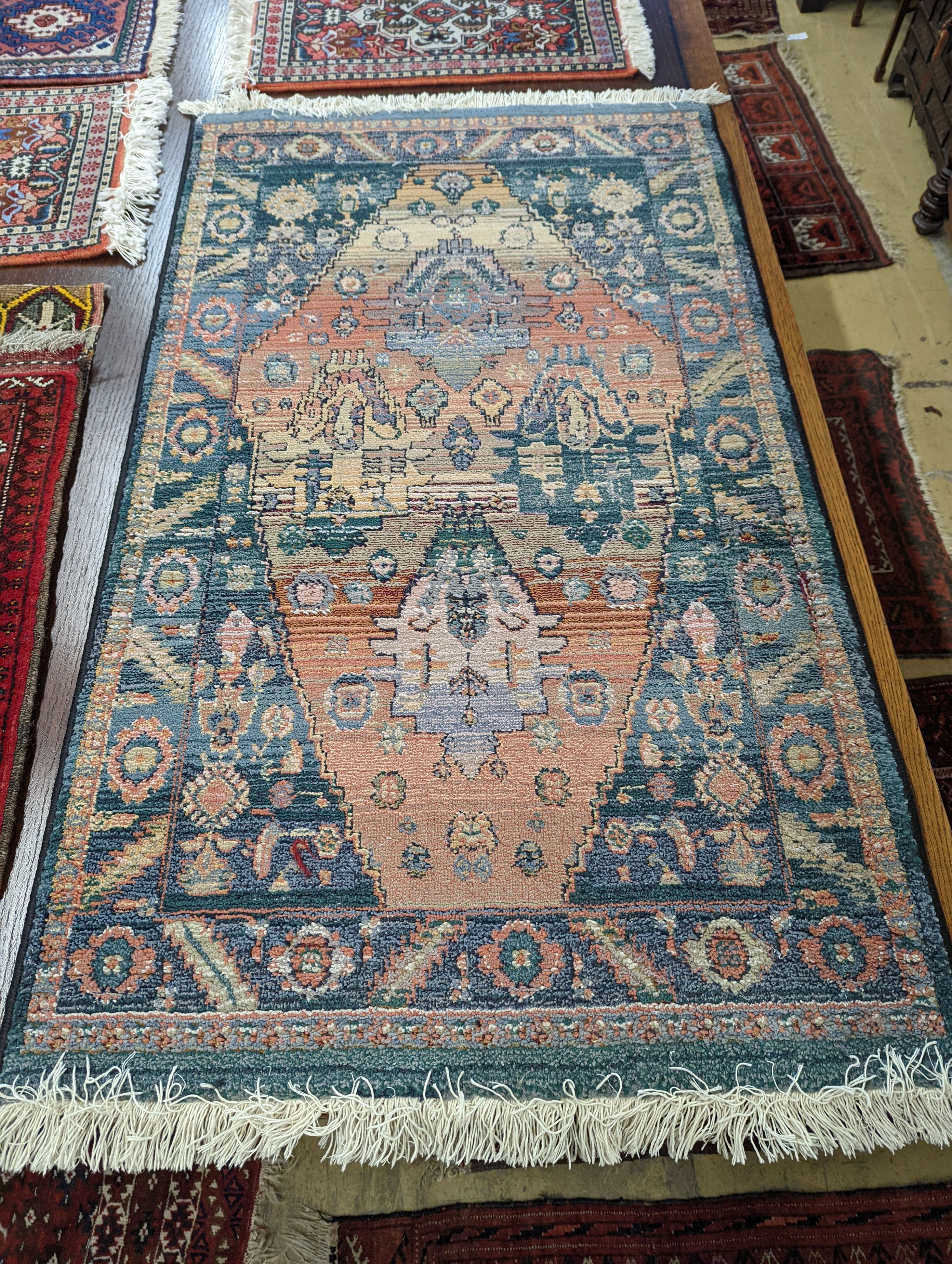 A Caucasian red ground mat, a Bokhara mat, three others and a blue ground rug, largest 136 x 80cm (6)
